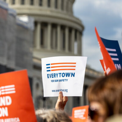 An Everytown sign is raised in a crowd in front of the Capitol