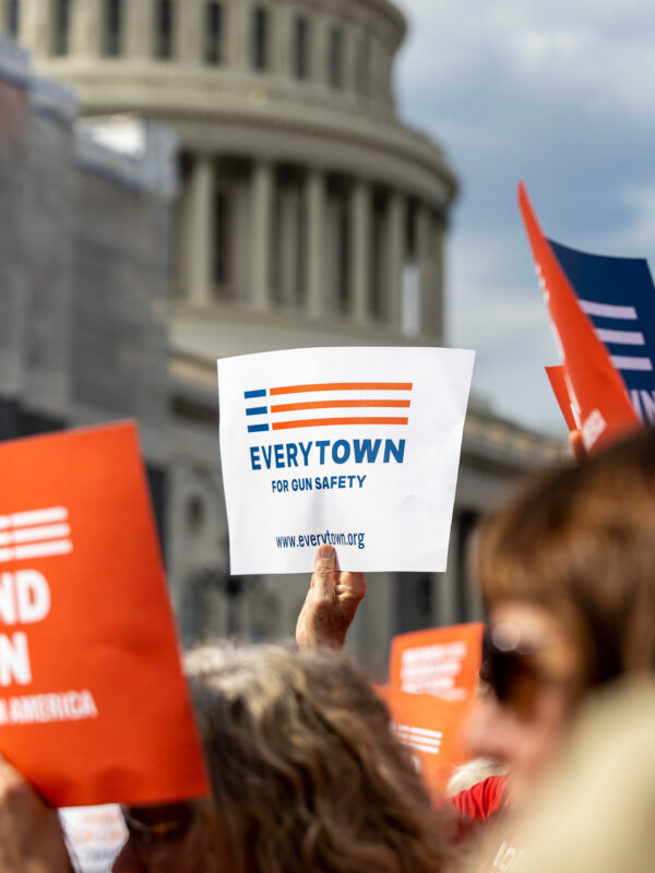 An Everytown sign is raised in a crowd in front of the Capitol