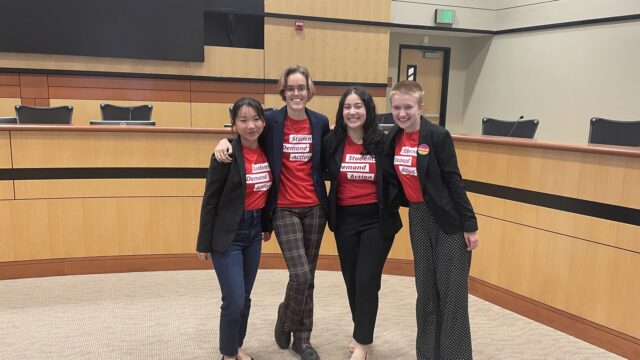 Flynn Williams and three other Students Demand Action volunteers smile for a photo together