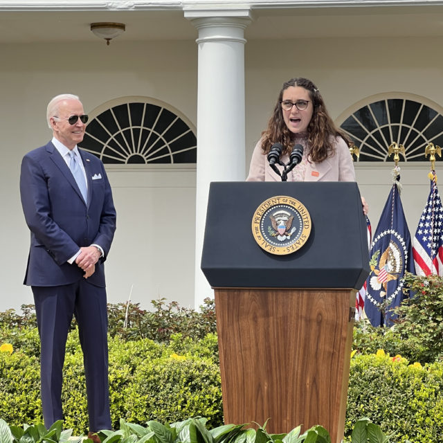 Gun violence survivor Mia Tretta speaks at the White House podium, with President Biden standing off to the side