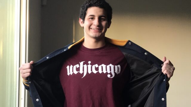 Justin Funez smiles while showing off his uchicago shirt