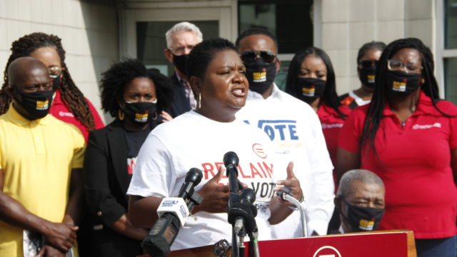 Sadiqa speaks at the podium at an event