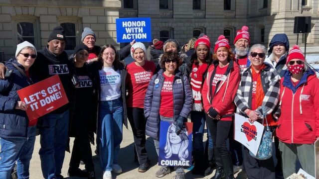Michigan Moms Demand Action volunteers pose for a photo holding signs