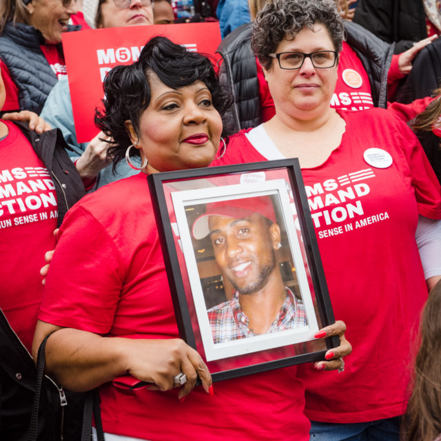 A survivor of gun violence hold the photo of their loved one at an Advocacy Day event in Georgia