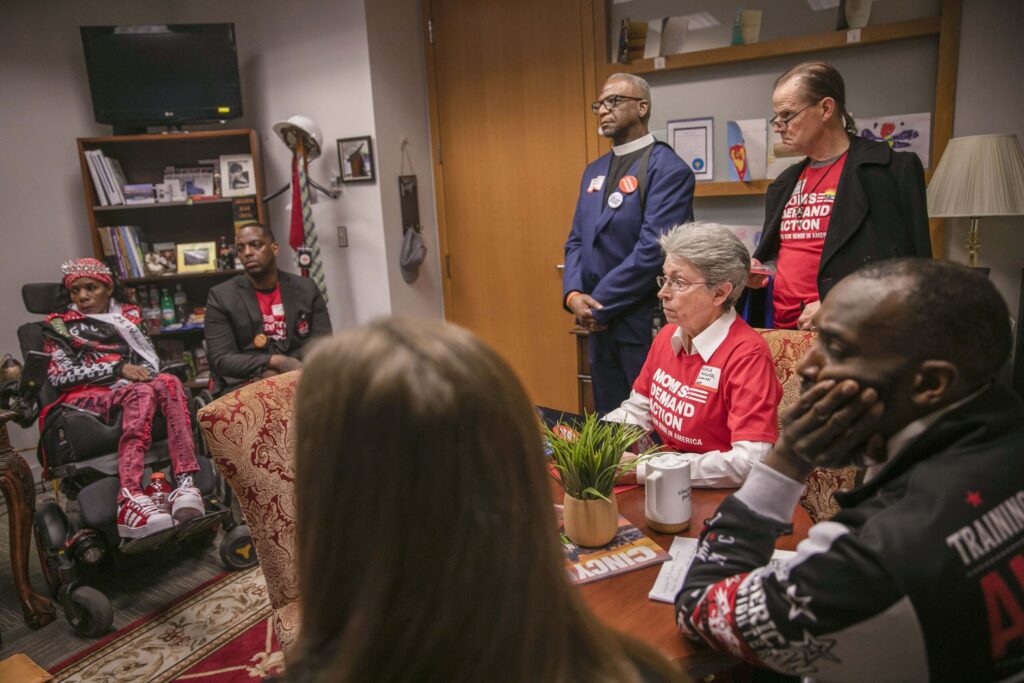 A group of Moms Demand Action volunteers and gun violence survivors from Ohio sit in an elected official's office during a Moms Demand Action advocacy day.