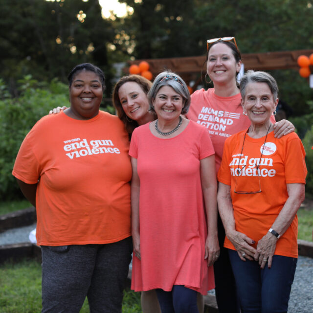 Moms Demand Action volunteers pose for a photo wearing Wear Orange t-shirts