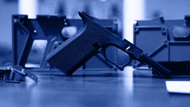 A ghost gun frame rests on a table. The image is blue-tinged.